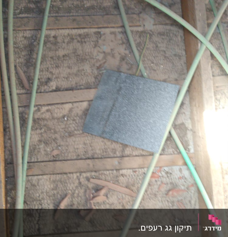 חוטים ירוקים על גג עץ עם לוח אפור